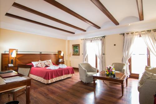 a bedroom with a bed and a living room at Hotel Abades Guadix in Guadix