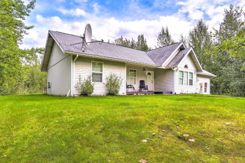 a white house with a grassy yard at Charming Wasilla Retreat Walk to Lake Lalen! in Wasilla