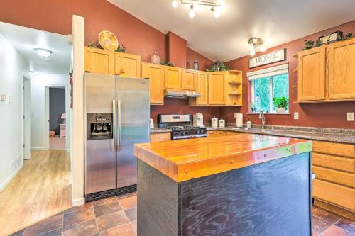 a kitchen with wooden cabinets and a stainless steel refrigerator at Charming Wasilla Retreat Walk to Lake Lalen! in Wasilla