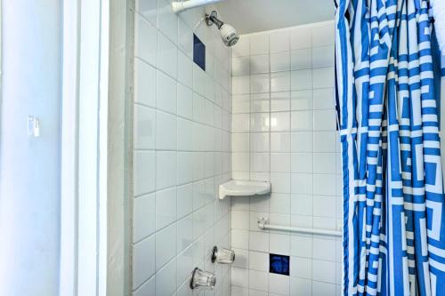 a bathroom with a shower with a blue and white shower curtain at Quaint Avalon Cottage Less Than Half-Mi to Beaches! in Avalon