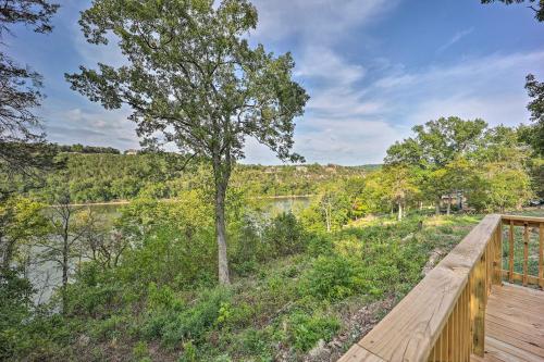 a wooden deck with a tree and a river at Private Eureka Springs Retreat with Hot Tub! in Eureka Springs