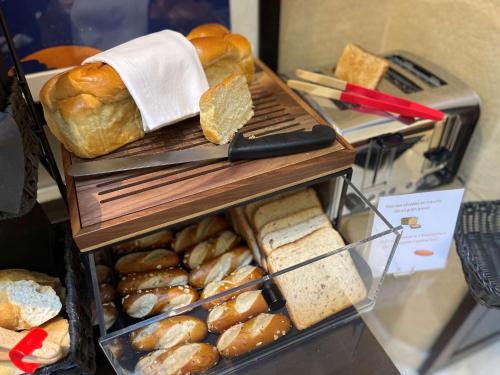 a bunch of bread and pastries on a shelf at Best Western Plus Hotel Sydney Opera in Paris