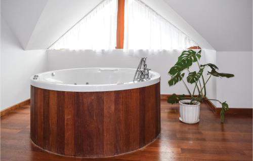 a large wooden tub in a room with a plant at Beautiful Home In Gardna Wielka With Kitchen in Gardna Wielka