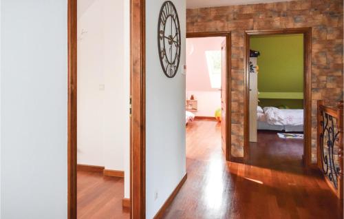 a hallway with a clock on a brick wall at Beautiful Home In Gardna Wielka With Kitchen in Gardna Wielka