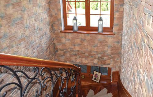 a staircase with a brick wall and a window at 3 Bedroom Awesome Home In Gardna Wielka in Gardna Wielka