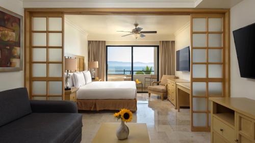 um quarto de hotel com uma cama e uma sala de estar em Meliá Puerto Vallarta – All Inclusive em Puerto Vallarta