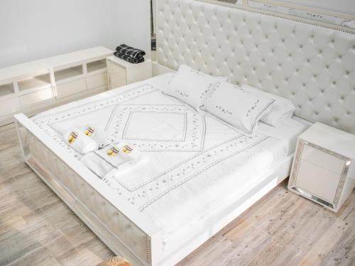 a white bed with white sheets and pillows at Glamping Ganbare in Villeta