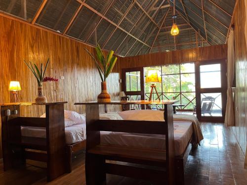 a bedroom with a bed and two tables in a room at Sotupa Eco Lodge in Puerto Maldonado