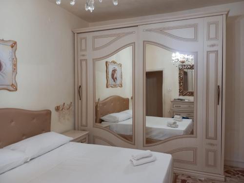 1 dormitorio con 2 camas y un espejo grande en Casa Vacanze La Fulgentissima, en Naro