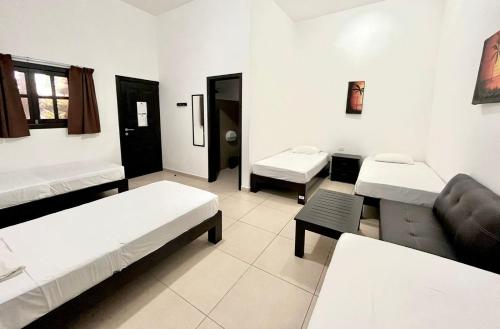 a room with two beds and a couch at We playa Hotel in Playa del Carmen