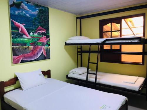 two bunk beds in a room with a painting on the wall at Hostal La Esperanza in Leticia