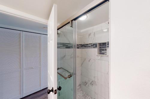 a shower with a glass door in a bathroom at White Sands Resort #108 in Kailua-Kona