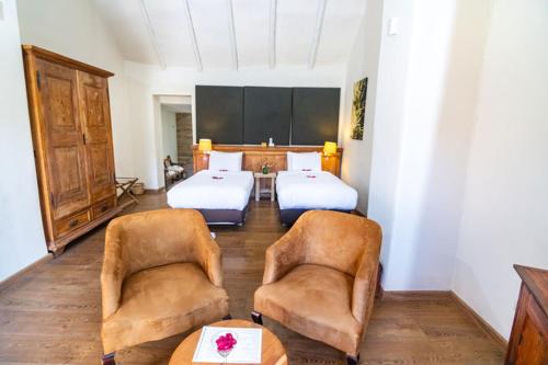 a room with two beds and two chairs and a table at Colca Lodge Spa & Hot Springs in Yanque