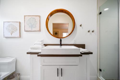 een badkamer met een witte wastafel en een spiegel bij The Little Crab Shack in Dana Point