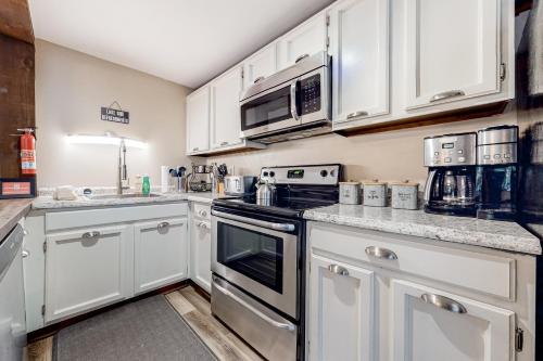 a kitchen with white cabinets and a stove top oven at Big Boulder Bliss in Lake Harmony