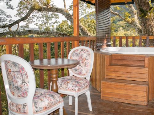 a table and two chairs on a deck with a bath tub at Glamping Ganbare in Villeta
