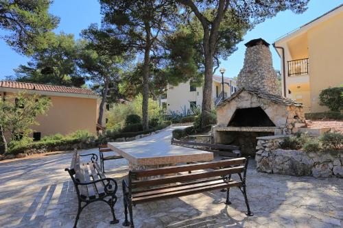 a bench and a table and a stone oven at Apartments by the sea Rogoznica - 3196 in Rogoznica
