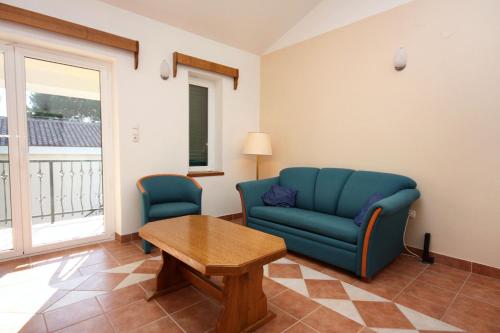 a living room with a blue couch and a table at Apartments by the sea Rogoznica - 3196 in Rogoznica