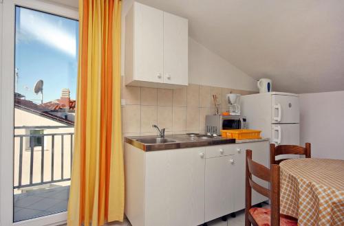 a kitchen with a sink and a refrigerator and a window at Apartments with a parking space Duce, Omis - 3190 in Duće
