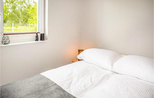 1 cama blanca en un dormitorio con ventana en 2 Bedroom Lovely Home In Dabki, en Dąbki