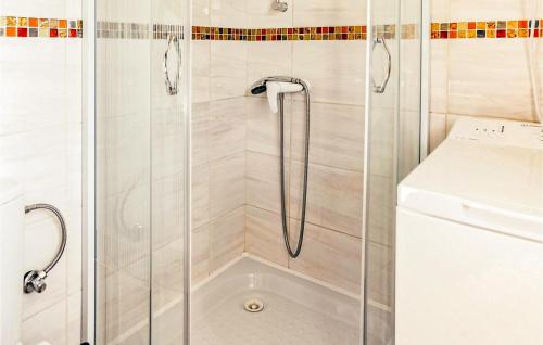 a shower with a glass door next to a washing machine at 2 Bedroom Lovely Home In Dabki in Dąbki