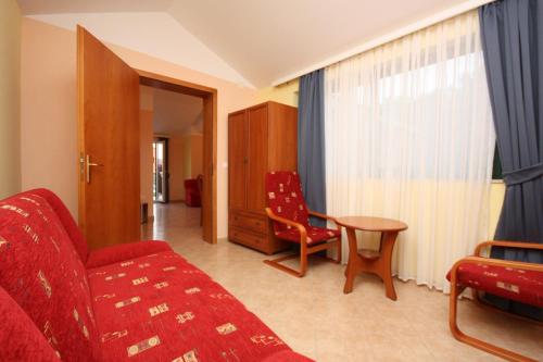 a living room with a red couch and a table at Apartments by the sea Rogoznica - 3200 in Rogoznica