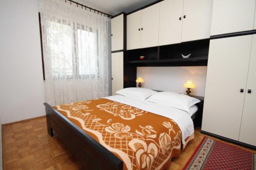 a bedroom with a large bed and a large window at Apartments and rooms with parking space Krk - 3231 in Vrh