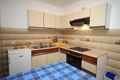 a small kitchen with a sink and a stove at Apartments and rooms with parking space Krk - 3231 in Vrh