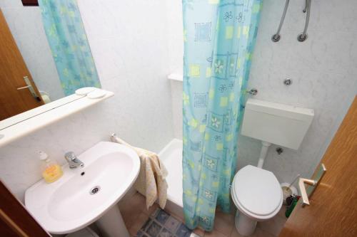 a bathroom with a sink and a toilet and a shower curtain at Triple Room Krk 3231a in Vrh