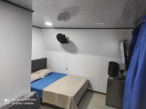 a bedroom with a bed and a fan on the wall at Cabañas Mirador La Roca in Melgar