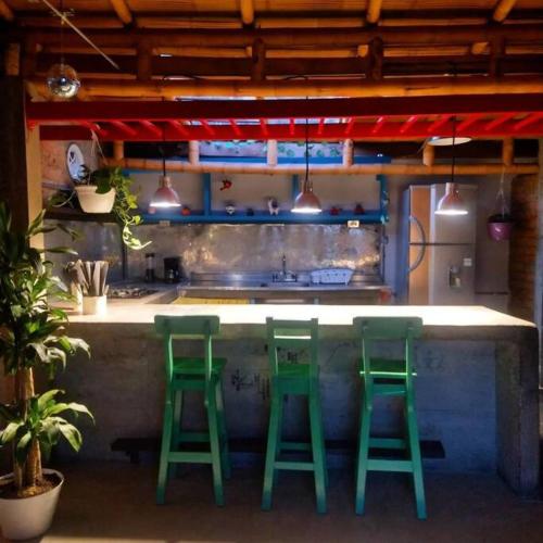 una cocina con dos taburetes verdes en un mostrador en Apartamento la 15 en Pereira