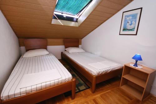 two beds in a small room with a window at Apartments by the sea Selce, Crikvenica - 3240 in Selce