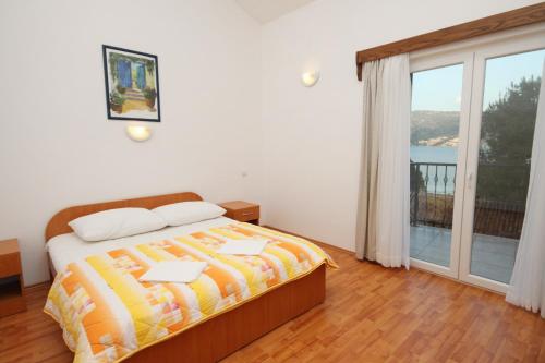 ein Schlafzimmer mit einem Bett und einem großen Fenster in der Unterkunft Apartments by the sea Rogoznica - 3262 in Rogoznica