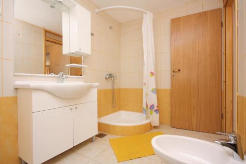 a bathroom with a sink and a toilet and a tub at Family friendly seaside apartments Jagodna, Hvar - 3250 in Jelsa