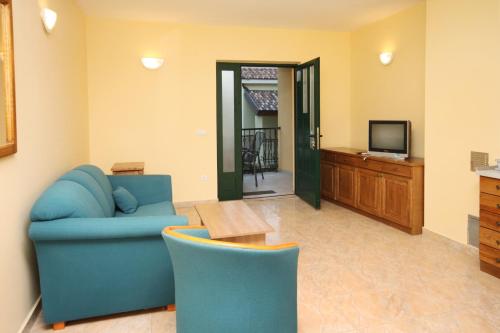 a living room with a blue couch and a television at Apartments by the sea Rogoznica - 3265 in Rogoznica