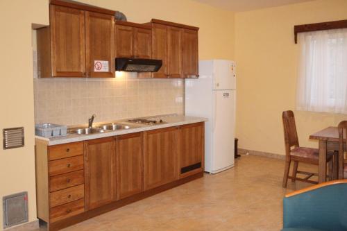 a kitchen with wooden cabinets and a white refrigerator at Apartments by the sea Rogoznica - 3265 in Rogoznica