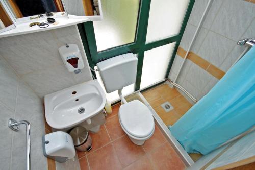 a bathroom with a white toilet and a sink at Double Room Rogoznica 3266a in Rogoznica