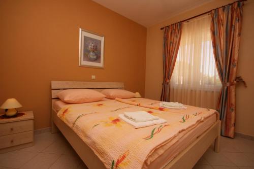 a bedroom with a bed with two towels on it at Apartments with a parking space Novalja, Pag - 3294 in Novalja