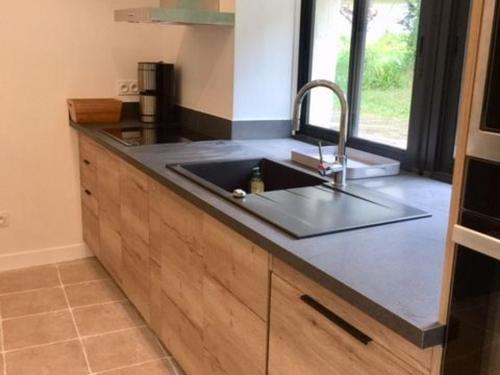 a kitchen with a sink and a counter top at Charmant Gîte Familial Rénové avec 3 Chambres, Cheminée et Jardin, Proche Le Mans - FR-1-410-332 in Le Mans