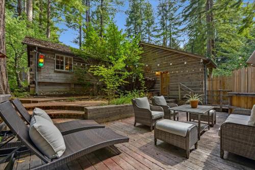 un patio con sillas, mesas y una cabaña en Log-Cabin Home Retreat - Walk to Restaurants Trails Hiking & Biking en Palo Alto