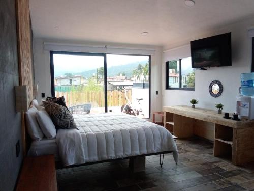 a bedroom with a large bed and a large window at Casa Nicolás in Valle de Bravo