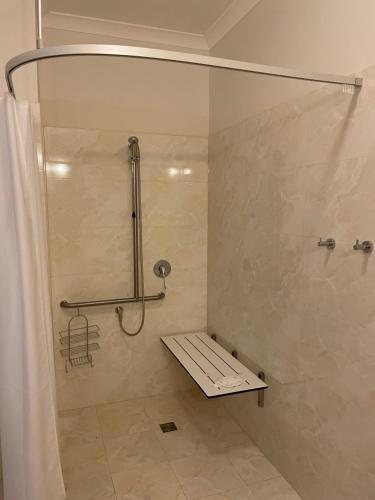 a bathroom with a shower with a bench in it at Foothills in Lilydale