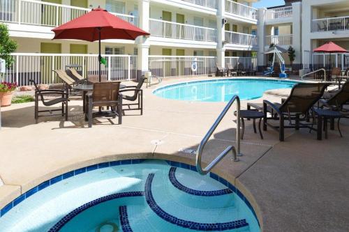 a swimming pool with chairs and tables and a hotel at Baymont Inn & Suites by Wyndham Tempe University/Phoenix in Tempe