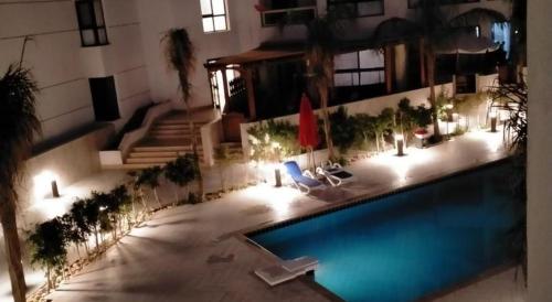 a swimming pool in a large building with lights at Porto Said apartment in Port Said