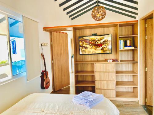 Un dormitorio con una cama y una guitarra. en Ruitoque Apartamento Campestre Maravillosa Vista en Floridablanca