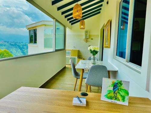 a room with a table and chairs and windows at Ruitoque Apartamento Campestre con Gran Vista in Floridablanca