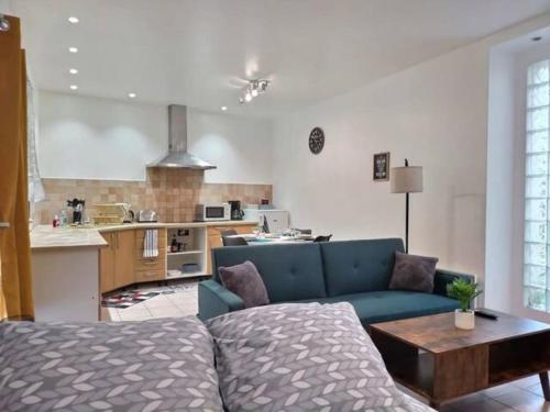 un soggiorno con divano blu e una cucina di CHATENAY 4 · Cozy Studio with car park and terrace a Châtenay-Malabry