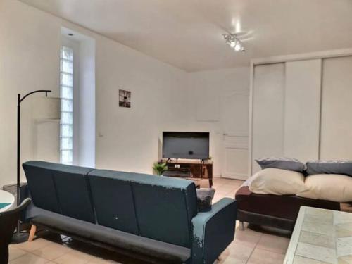 un soggiorno con divano e TV di CHATENAY 4 · Cozy Studio with car park and terrace a Châtenay-Malabry