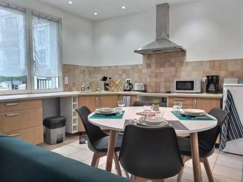 une cuisine avec une table et des chaises dans une cuisine dans l'établissement CHATENAY 4 · Cozy Studio with car park and terrace, à Châtenay-Malabry