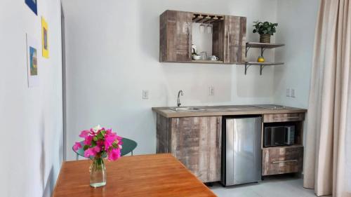 una cocina con una mesa con un jarrón de flores. en Hibiscus Beach House, en Willemstad